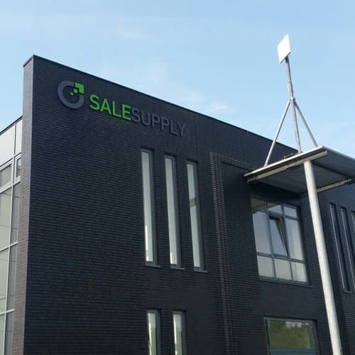 Frontside of darkgrey office building with Salesupply logo